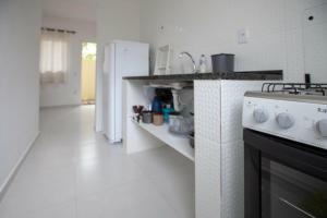 a kitchen with a stove and a white refrigerator at Recanto do Camargo in Ubatuba