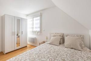 - une chambre blanche avec un grand lit et une fenêtre dans l'établissement GRAND CONFORT, Appartement Osny, à Osny