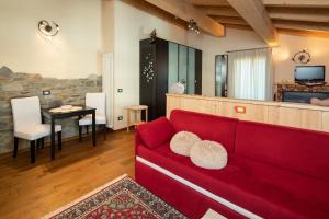 a living room with a red couch and a table at Hotel Krone in Livigno