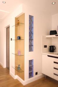 a kitchen with glass shelves on the wall at Orchard Road Studio Apartment in Hook Norton