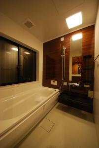 a bathroom with a bath tub and a large window at Cominka Hotel Shiki no Ie - Vacation STAY 89847 in Mitake
