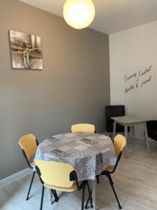 une salle à manger avec une table et des chaises jaunes dans l'établissement Zenitude, à Jumet