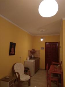 Spiti Mitsis في أريلاز: مطبخ مع ثلاجة وطاولة وكراسي