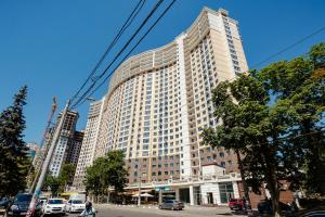 Un gran edificio alto en una calle de la ciudad con coches. en Apartments in Arcadia Vip, en Odessa