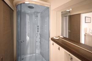 a shower with a glass door in a bathroom at Orchard Road Studio Apartment in Hook Norton