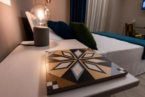 a table with a lamp on it next to a bed at b&b Le Maioliche in Milazzo
