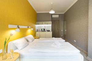 a bedroom with two white beds and a yellow wall at Opera Passage Hotel & Apartments in Lviv