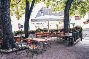 a group of tables and chairs with an umbrella at Gasthaus zum Löwen in Frankfurt/Main