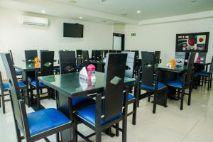 a dining room with black tables and blue chairs at Ayenda 1315 Candiac in Barranquilla