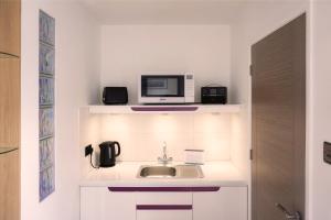 a small kitchen with a sink and a microwave at Orchard Road Studio Apartment in Hook Norton
