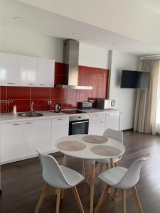 a kitchen with a table and chairs in a room at Apartamentai Fortuna in Kaunas