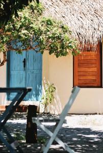 a building with a blue door and a chair in front at Vila Prana in Barra Grande