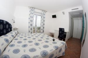 a bedroom with a bed with a blue and white comforter at Yachting Club Mare in Patti