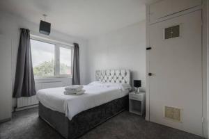 a white bedroom with a bed and a window at Hullidays - The Auckland House University Quarter in Hull