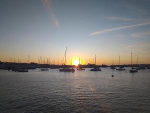 a group of boats in the water at sunset at Punta del Este -Edificio Kennedy Apto 106 in Punta del Este