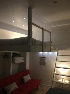 une chambre avec un lit superposé et un canapé rouge dans l'établissement Lovely Studio, à Bourges