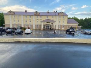 a large building with cars parked in a parking lot at SureStay Plus by Best Western Jonestown Lebanon Valley in Jonestown