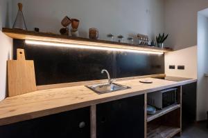 uma cozinha com um lavatório e um quadro na parede em Contessa Pace - Luxury flat em Selvino
