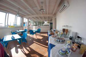 a room with a table with blue chairs and food on it at Yachting Club Mare in Patti