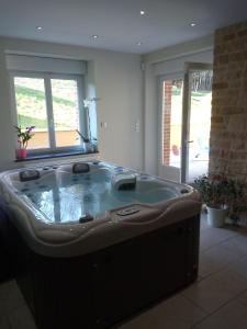 uma banheira de hidromassagem numa sala de estar em Le Moulin d'Harcy em Lonny