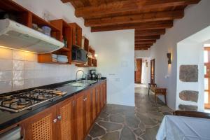 a kitchen with wooden cabinets and a stove top oven at El Inti 1 in Tinajo