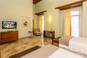 una camera d'albergo con letto e TV di Hotel Parador de Alcalá a Città di Oaxaca