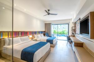 a hotel room with two beds and a flat screen tv at Hyatt Zilara Cap Cana - Adults Only in Punta Cana