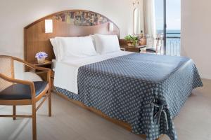 1 dormitorio con 1 cama grande con manta azul y blanca en Hotel Strand, en Bellaria-Igea Marina