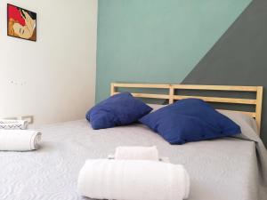 a bed with blue and white pillows on it at Saline nello Stagnone in Marsala