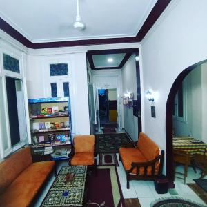 een woonkamer met een bank, stoelen en een tafel bij Transit Alexandria Hostel in Alexandrië