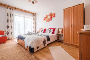 a bedroom with a bed and a large window at Willa Wrzos in Zakopane