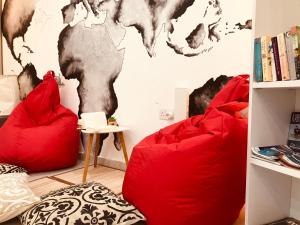 two red chairs in a room with a map on the wall at LA 88 Boutique in St Paul's Bay