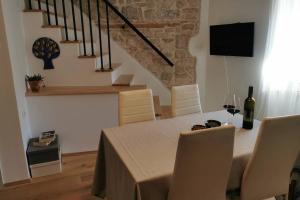 Casa Porta Verde في بال: غرفة طعام مع طاولة مع كأس من النبيذ