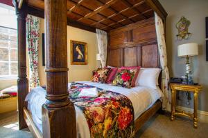 1 dormitorio con 1 cama con cabecero de madera en The Rutland Arms Hotel, Bakewell, Derbyshire, en Bakewell