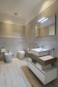 un bagno con lavandino, water e specchio di Gli Archi Spoleto a Spoleto