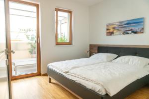 ラグンドにあるFerienwohnung mit Garage, Fahrradraum und sehr großer sonnenverwöhnten Terrasseのベッドと窓のある寝室