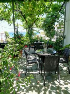a patio with a table and chairs and trees at Hotel Erato in Chorefto