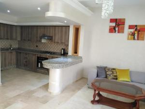 cocina con barra y sofá en una habitación en Villa à Savannah Beach sidi rahal en Sidi Rahal