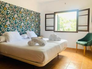 a bedroom with two beds and a window and a chair at Sol Port Soller in Port de Soller