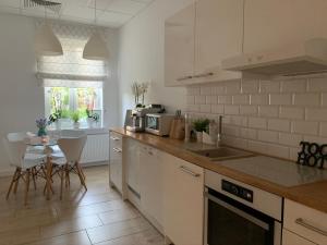 a kitchen with white appliances and a table with chairs at Toscana in Łódź
