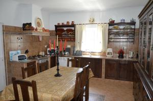 a kitchen with a table with chairs and a window at Monte O Alentejo in Ourique