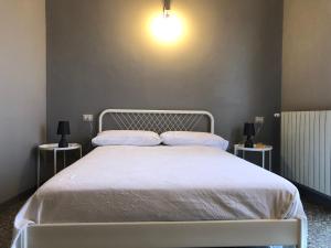 1 dormitorio con 1 cama blanca y 2 mesitas de noche en Risveglio nel Borgo en San Donato di Ninea