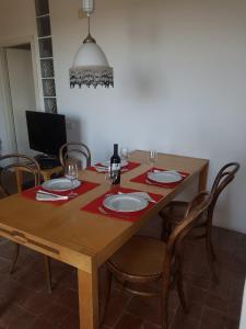 drewniany stół z krzesłami i talerzami oraz kieliszki do wina w obiekcie Casa a Serrazzano w mieście Serrazzano