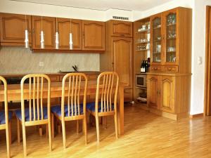 a kitchen with wooden cabinets and a table and chairs at Ravishing Apartment in La Tzoumaz in Verbier in La Tzoumaz