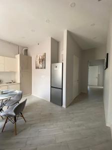 a kitchen with a refrigerator and a table and chairs at Serbska Apartment in Lviv