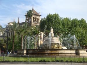 una fuente con una estatua delante de un edificio en UNICO ALCAZAR Apartment, en Sevilla