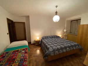 1 dormitorio con 2 camas y lámpara en Mizhoun a Pontebernardo en Pietraporzio