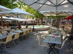 un restaurante con mesas, sillas y una fuente en Nyx suite d’exception, en Dijon