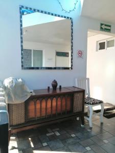 a mirror in a room with a table and a chair at Hostal Maple in Querétaro