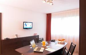 a room with a table with a laptop on it at Oceania Quimper in Quimper